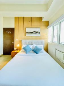 une chambre avec un grand lit blanc avec des oreillers bleus dans l'établissement 15 Elegant Urban Suite, à Cari Mayor 12 autres photos