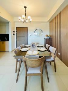 une salle à manger avec une table, des chaises et un lustre dans l'établissement 15 Elegant Urban Suite, à Cari Mayor
