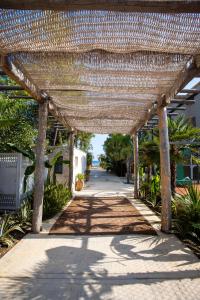 a wicker pergola with a pathway in a yard at MAKO Sea & Suites in Pefkochori +62 photos