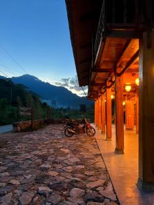 a motorcycle parked next to a building on a stone road at Muong Tra Stream Homestay in Làng Cac