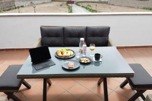 a table with a laptop and a plate of fruit at Los Adejo in Moya