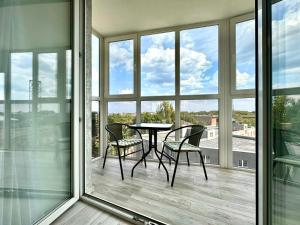 a table and chairs on a balcony with windows at ApartPoltava апартаменти бізнес-класу в престижній НОВОбудові з панорамним балконом ЦЕНТР in Poltava