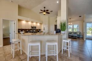 a kitchen with a bar with white stools at Villa Lazy Days by CoralVilla - comfortable, pool & spa in Shell Point Village