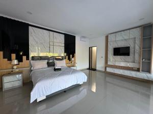 een slaapkamer met een groot bed en een televisie bij Gecko Villa in Lovina +29 foto's