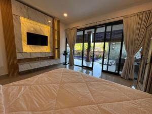 een slaapkamer met een bed en een tv aan de muur bij Gecko Villa in Lovina