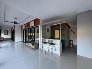 een woonkamer met een bar met krukken bij Gecko Villa in Lovina