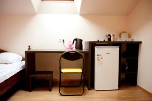 a small kitchen with a chair and a refrigerator at Coffee Apartments in Jūrmala