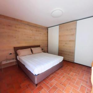 a bedroom with a bed with a wooden wall at relaxing green panorama in Margno +18 photos