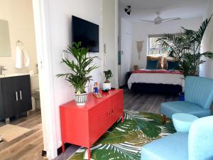 a living room with a red dresser and a bedroom at Namaste Suite in Southbroom in Southbroom