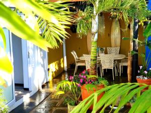 a patio with tables and chairs and plants at Namaste Suite in Southbroom in Southbroom