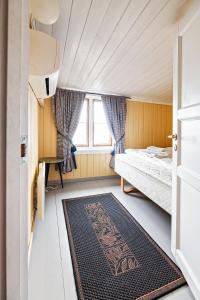 een kleine slaapkamer met een bed en een raam bij Rorbu burekka, Stamsund in Stamsund