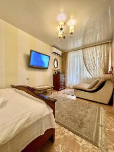 a bedroom with a bed and a flat screen tv at ApartPoltava Французький шик у центрі Полтави, 4 спальних місця, Корпусний парк in Poltava