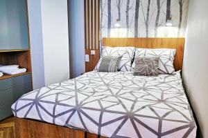 a bedroom with a large bed with pillows at Apartament Skandynawski FV VAT in Nowy Sącz
