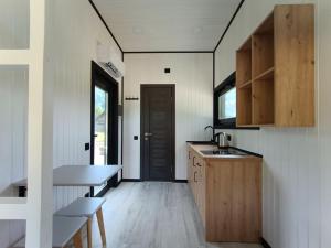 a kitchen with a table and a sink and a door at Екосадиба Водограй in Kvasy