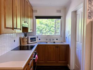 a kitchen with a sink and a window at Cozy Lovely flat 3km to CBD in Glenunga +6 photos