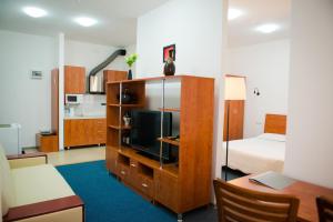 a room with a bedroom with a bed and a tv at Residence Keruen in Atyrau