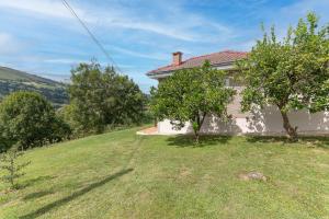 a house on a hill with a grass yard at La Casuca de Barcena in Bárcena