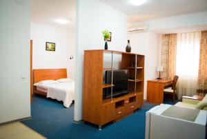 Cette chambre comprend un lit et une télévision. dans l'établissement Residence Keruen, à Atyraū
