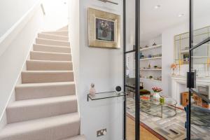 a staircase in a home with white walls at Delightful Notting Hill 2 bed House with garden in London