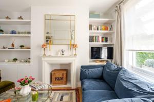 a living room with a blue couch and a glass table at Delightful Notting Hill 2 bed House with garden in London