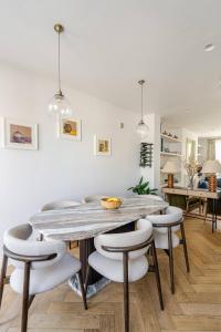 a dining room with a large wooden table and chairs at Delightful Notting Hill 2 bed House with garden in London