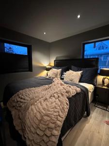 Un dormitorio con una cama grande y dos ventanas. en Villa Bella, en Lorenskog