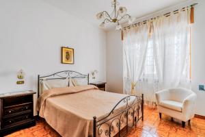 a bedroom with a bed and a chair and a window at Appartamento Maria a Racale in Racale