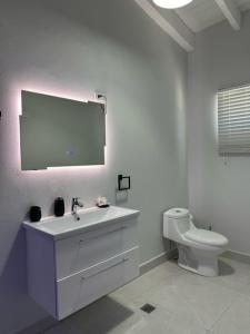 a white bathroom with a sink and a toilet at Executive Inn Aruba Room Swiss #5 in Oranjestad