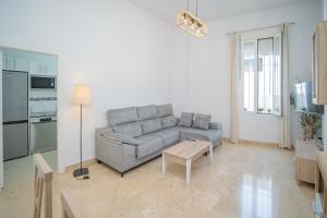 una sala de estar con un sofá y una mesa en Piso en el Casco Histórico, en Sanlúcar de Barrameda