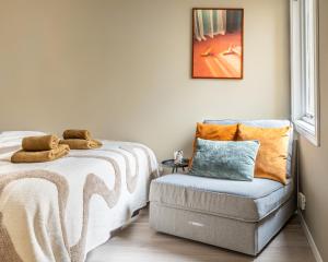 a bedroom with a bed and a chair next to a window at Beautiful apartment in the heart of Oslo! in Oslo