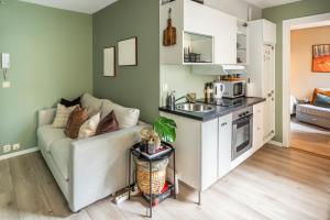 a living room with a couch and a kitchen at Beautiful apartment in the heart of Oslo! in Oslo
