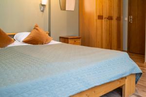 a bedroom with a bed with a blue comforter at Apartamenti Kurshi in Jūrmala