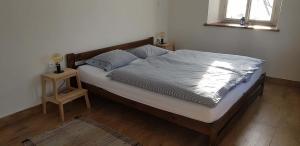 a bed in a bedroom with a night stand next to it at HabaChalupa in Šumperk