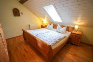 a bedroom with a bed and a window in a attic at Ferienhof Mayischhof in Lauperath