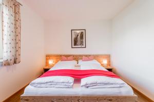 a bedroom with a bed with a red blanket on it at Ferienwohnungen Barbara in Stumm