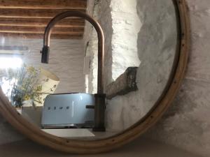 een spiegel die een broodrooster in een kamer reflecteert bij ARIA Kea Sunset Homes in Ioulida