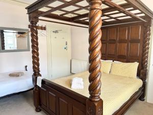 a canopy bed with a wooden frame in a bedroom at The Boho - 4 min walk to beach & town in Bournemouth
