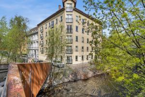 a large building in front of a river with trees at Beautiful apartment in the heart of Oslo! in Oslo