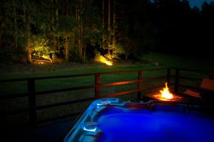 a hot tub with a fire in front of a fence at Cozy Forest Wellness Suite in Saint-Vith