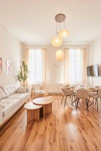 ein Wohnzimmer mit einem weißen Sofa und Tischen in der Unterkunft OLIVE Apartments - Terrasse - Zentral in Hannover