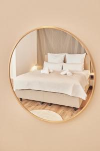 ein Schlafzimmer mit einem Bett in einem runden Spiegel in der Unterkunft OLIVE Apartments - Terrasse - Zentral in Hannover