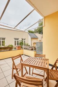 eine Terrasse mit einem Holztisch und 2 Stühlen in der Unterkunft OLIVE Apartments - Terrasse - Zentral in Hannover + 11 Fotos