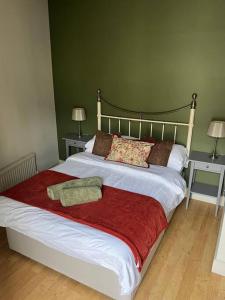 a bedroom with a large bed with two tables at Number 9 Market Street - Town centre 4 bedroom house with garden in Ballycastle