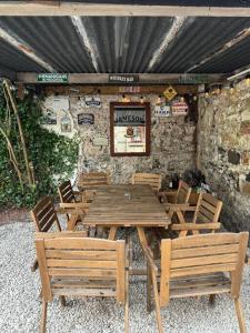 a wooden table and chairs in front of a stone wall at Number 9 Market Street - Town centre 4 bedroom house with garden in Ballycastle
