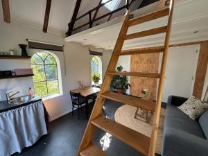 a tiny house with a bunk bed and a kitchen at Tiny House De Smederij in Peize
