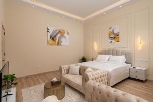 a white bedroom with a bed and a couch at Museum Studios in Cairo