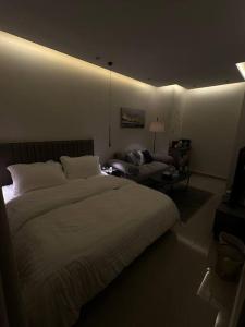 una camera da letto con un letto grande e un divano di استديو بموقع مميز بدخـول ذاتي a Riyad