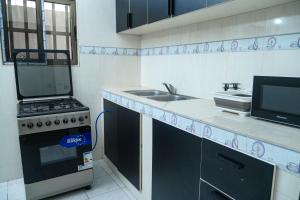 a kitchen with a stove and a sink at Condolind- Maison de confort in Lomé