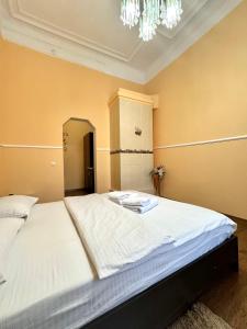 a large white bed in a room with a chandelier at ApartPoltava Будиночок з мангалом та терасою, Оглядовий майданчик, ОНОВЛЕНИЙ РЕМОНТ 2024, банківський чек in Poltava