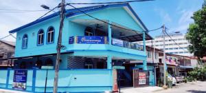 Kampong Batu MaungSunStar Hotel的街边的一栋蓝色建筑